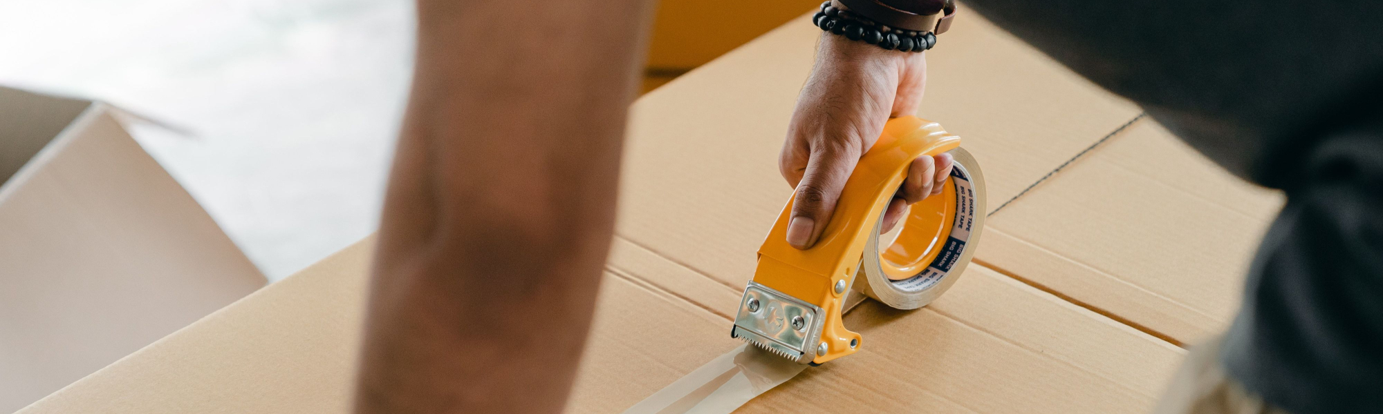 Outsourcing order fulfillment - woman taping up a box