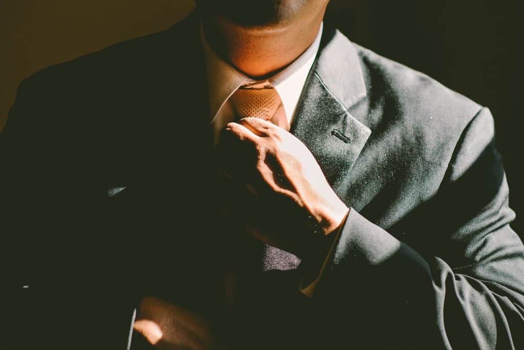 man pulling his tie